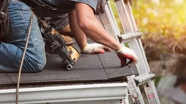 person-repairing-dark-colored-roofing-material